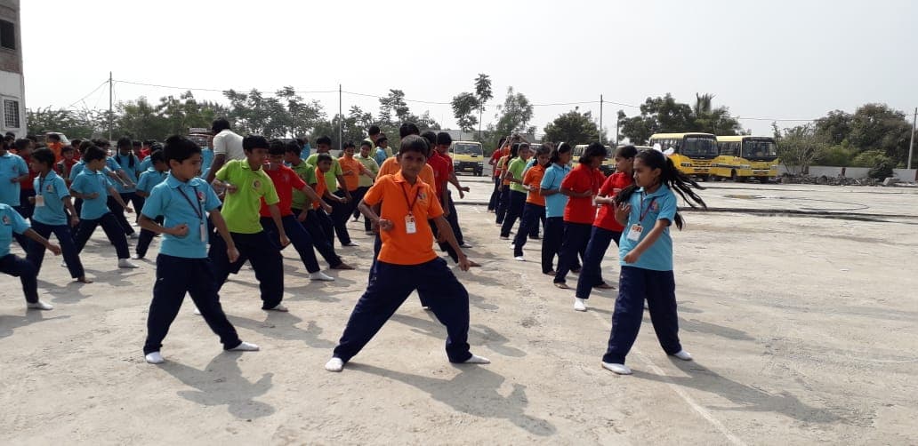Students in sports kit spread across the school ground during a mass drill