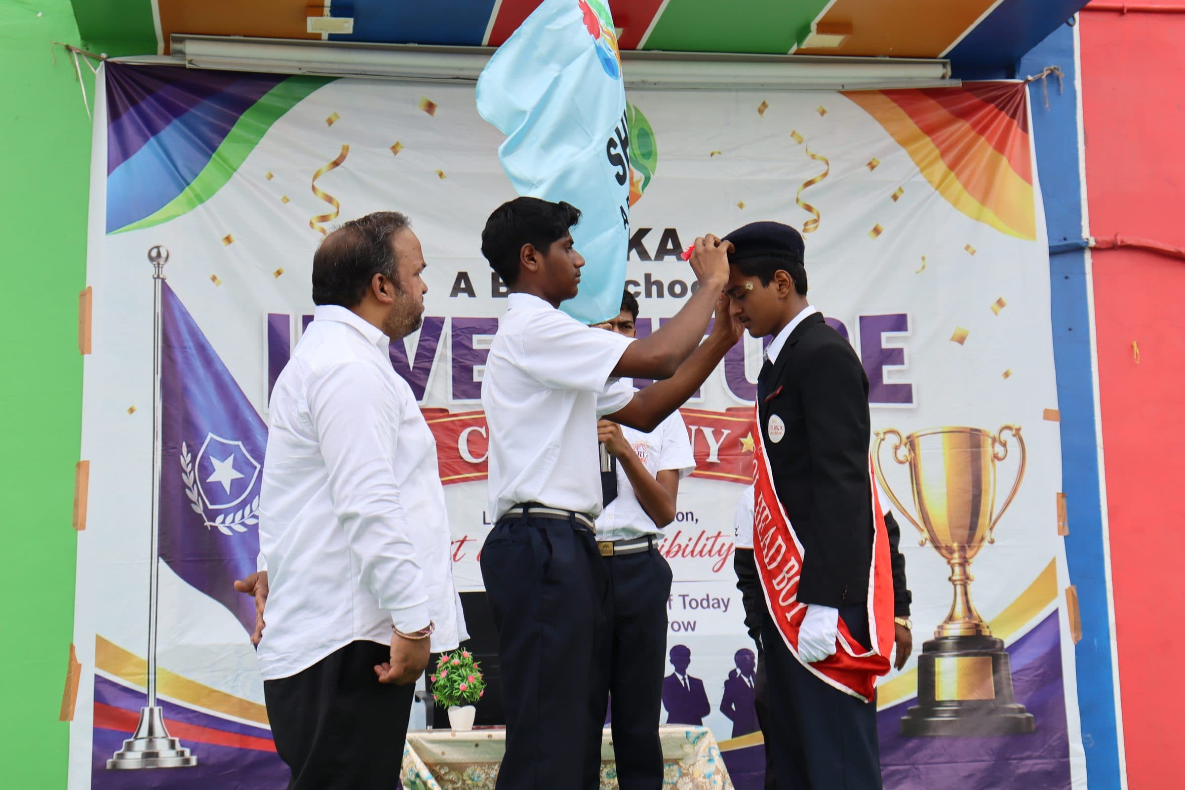 A senior student in school blazer receiving the badge of office at the investiture ceremony