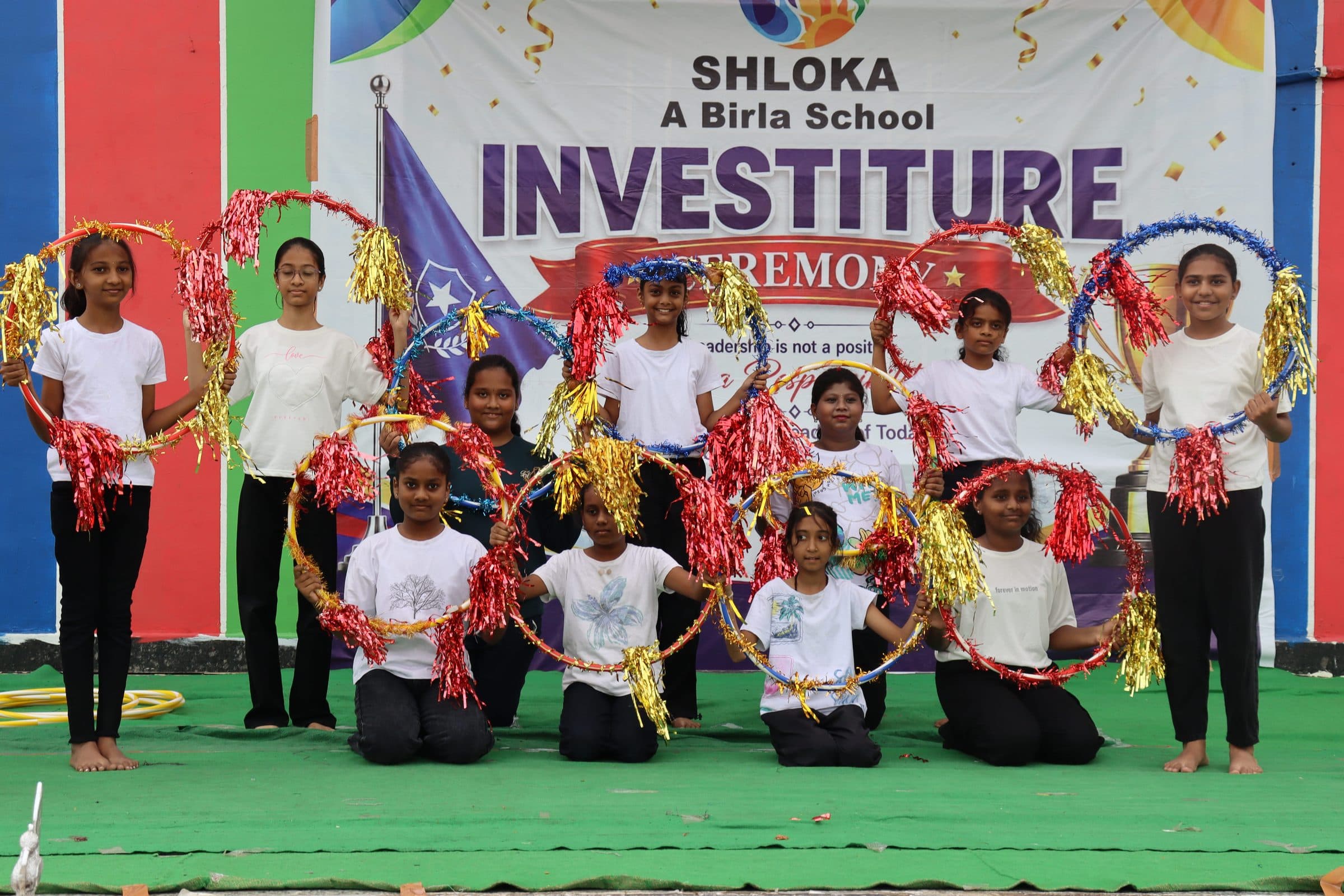 Children of the school performing with decorated hoops and pom-poms on stage