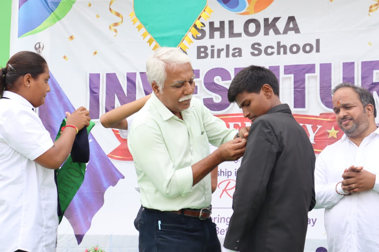 A student receiving the school sash at the SHLOKA - A Birla School investiture ceremony